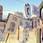 Una mujer cuelga carteles de chilenos desaparecidos en la cerca de Colonia Dignidad, que sirvió de centro de tortura de Pinochet.