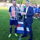 El capitán de la Deportiva, Yuri, recibió el trofeo Emma Cuervo tras vencer al Real Oviedo en el partido disputado en Navia. SDP