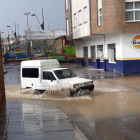 Un coche transita por las calles cercanas al parque de la Era ayer por la tarde, donde las alcantarillas no pudieron asumir el agua caída. DL