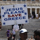 Un hombre sostiene una pancarta en la plaza Syntagma de Atenas.