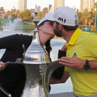 Sergio García besa a su novia, Angela Ankins, junto al trofeo del Omega Dubai Desert Classic.