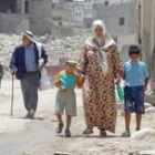 Una mujer palestina pasea con sus dos hijos por el campo de refugiados de Jenín