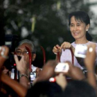 Suu Kyi saluda a sus seguidores desde su casa.