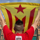 Un hombre con la bandera secesionista ayer, en el paseo Lluís Companys de Barcelona. ENRIC FONTCUBERTA