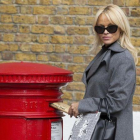 Pamela Anderson posa ante los fotográfos, mientras envía la carta a la primera ministra británica, Theresa Mai.