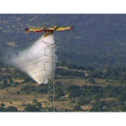 Una avioneta trabaja en las labores de extinción del incendio declarado en el término municipal de Tres Cantos.