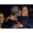 Obama abraza a su mujer, Michelle, en presencia de su hija Malia después de su discurso de despedida en Chicago.