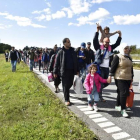 Un gran grupo de inmigrantes, sobretodo sirios, andan por una carretera en Dinamarca en dirección a Suecia, su destino.