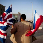 Un hombre con las banderas británica y francesa, en Bengasi.