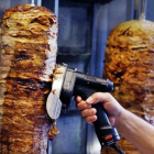 Un hombre corta carne de kebab en un establecimiento de Fráncfort.