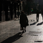 Una señora mayor camina por las calles de León cargada con las bolsas con la compra. JESÚS F. SALVADORES
