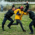 Policías franceses intentan parar a los inmigrantes que buscan colarse al Eurotúnel en Calais este miércoles.