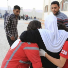 Voluntarios de la Cruz Roja siria ayudan a una mujer, este lunes, en Muadamiya al Sham, al suroeste de Damasco.