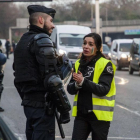 Una manifestante con el chaleco amarillo, símbolo de la protesta, habla con un policía, esta mañana en los alrededores de París.