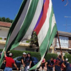 Jóvenes levantan un pendón en la fiesta de la romería de Calzada de la Valdería.