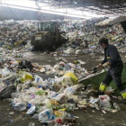 Un empleado trabaja con residuos en las instalaciones de la planta de tratamiento y selección de envases de Gavà, para su posterior reciclaje.