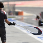 Un mecánico de Sauber espera a su monoplaza en la calle de boxes con la piruleta en sus manos.