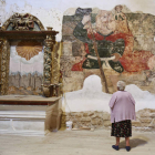 Una vecina observa la imagen del San Cristóbal, presumiblemente del siglo XIV, que ya ha sido restaurada en gran parte. SARA CAMPOS