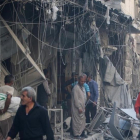 Miembros de la defensa civil siria y otras personas inspeccionan los edificios destrozados tras un bombardeo en el barrio de Al-Qaterji, controlado por los rebeldes, en Alepo, el 11 de octubre.