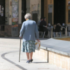 Una mujer mayor regresa a casa con la compra