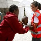 Una voluntaria juega con un indocumentado y con su madre.