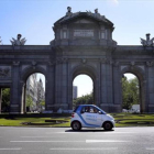 Un vehículo de Car2Go circula por la Puerta de Alcalá, en Madrid.