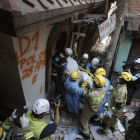 Varios miembros de los equipos de rescate de Corea y Omán recuperan un cadáver.