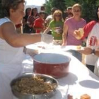 Una de las cocineras reparte las raciones de cordero elaborado a base de níscalos y boletus