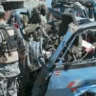 Un soldado iraquí inspecciona los restos de un coche bomba en un mercado del norte de Bagdad