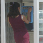 Una mujer llamando por teléfono en una de las cabinas telefónicas de León.