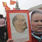 Una mujer sostiene una imagen de  Lenin, líder de la revolución rusa, durante una ofrenda floral