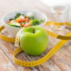 Manzana, cinta métrica y desayuno en una mesa.