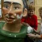 Dos mujeres durante la restauración del brazo de uno de los gigantes ponferradinos más veteranos