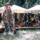 Un turista se refresca en una fuente para mitigar el fuerte calor