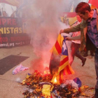 Varios manifestantes de la marcha ultra del 12-O en Barcelona queman una 'estelada'.