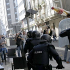La policía carga contra los manifestantes de Santiago, mientras estos les lanzan diversos objetos, este martes.