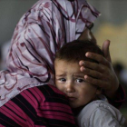 Una mujer siria consuela a su hijo, once días después de abandonar su casa tras un bombardeo del régimen en Marea, el pasado septiembre.