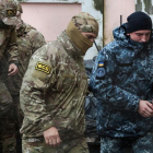 Militar ruso conduce a uno de los marineros detenidos