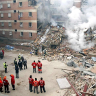 Bomberos y personal sanitario ante los restos del edificio que derrumbó la explosión de gas. DL