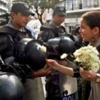 Una joven le obsequia flores a la policía en Quito
