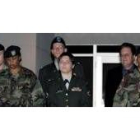 Lynndie England a su salida de la sala en uniforme militar, a donde fue esposada de pies y manos