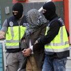 Agentes de policía trasladan a uno de los detenidos en Ceuta. reduan