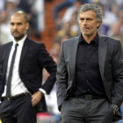 Jose Mourinho en primer plano y el técnico del Barça, Josep Guardiola, en el último derbi.