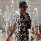Un turista se refresca en una fuente de Lisboa.