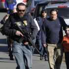 Agentes de policía custodian a padres e hijos de la escuela de Newtown tras la matanza del 2012.