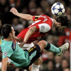 El azulgrana Xavi disputa el balón con Cesc Fábregas del Arsenal, durante el partido de ayer.