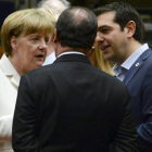 El primer ministro griego, Alexis Tsipras (dcha) habla con la canciller alemana Angela Merkel (izda) y el presidente francés François Hollande (c) durante la reunión del Eurogrupo en Bruselas.