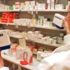 Una farmaceútica sostiene una caja de un medicamento antigripal