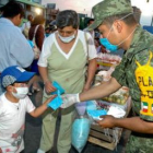 Un miembro del Ejército mexicano reparte mascarillas a la población para evitar los contagios