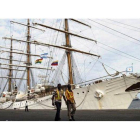 Dos trabajadores portuarios pasan ante el buque insignia de la Marina argentina, retenido en Tema, el 23 de octubre.
